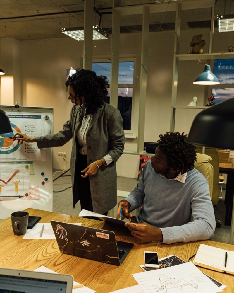 Two colleagues reviewing a project at a desk in a bright studio office